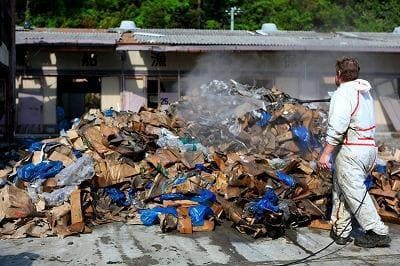 Volunteers spraying Activated EM・1® under floors, surroundings and on garbage from a seaweed factory