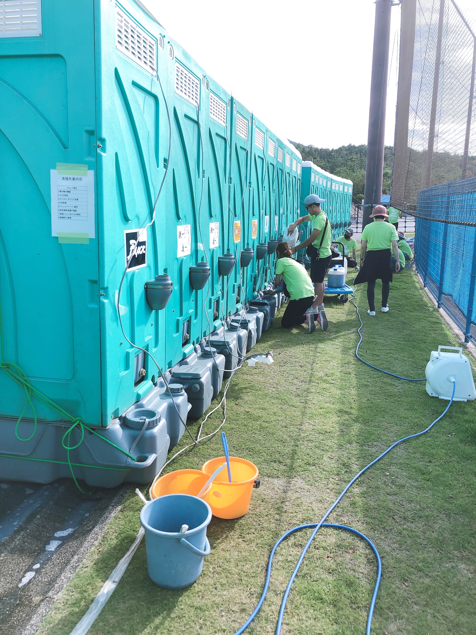 Volunteers applying EM in the microbial toilets